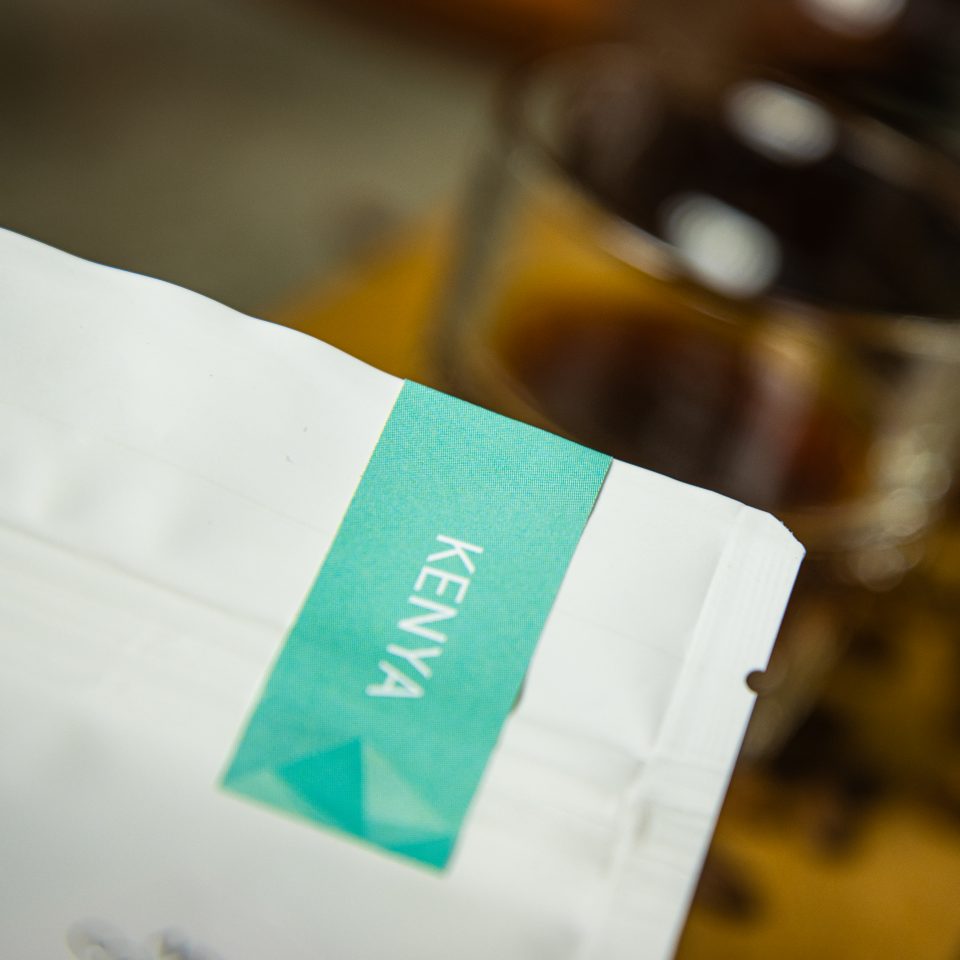 Kenya Kirinyaga roasted by Ikigai Coffee in a bag with filter coffee on the background